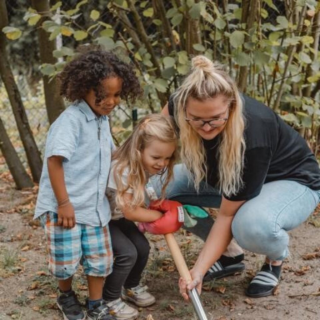 Kinder ernten im Garten.